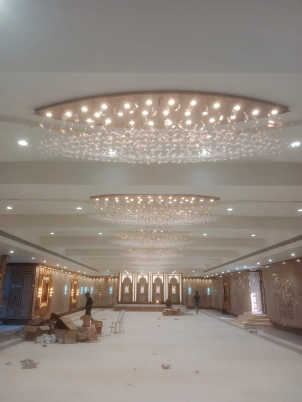 Premium China chandelier installation in luxury hotel banquet hall and commercial project with high ceiling crystal lighting setup in India